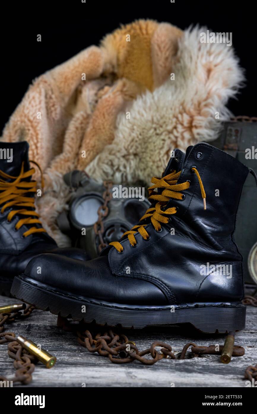 Botas de cuero con cadenas oxidadas y conchas de bala con militares máscara  de gas y pelaje de pelo en el fondo descansando sobre madera tabla  Fotografía de stock - Alamy