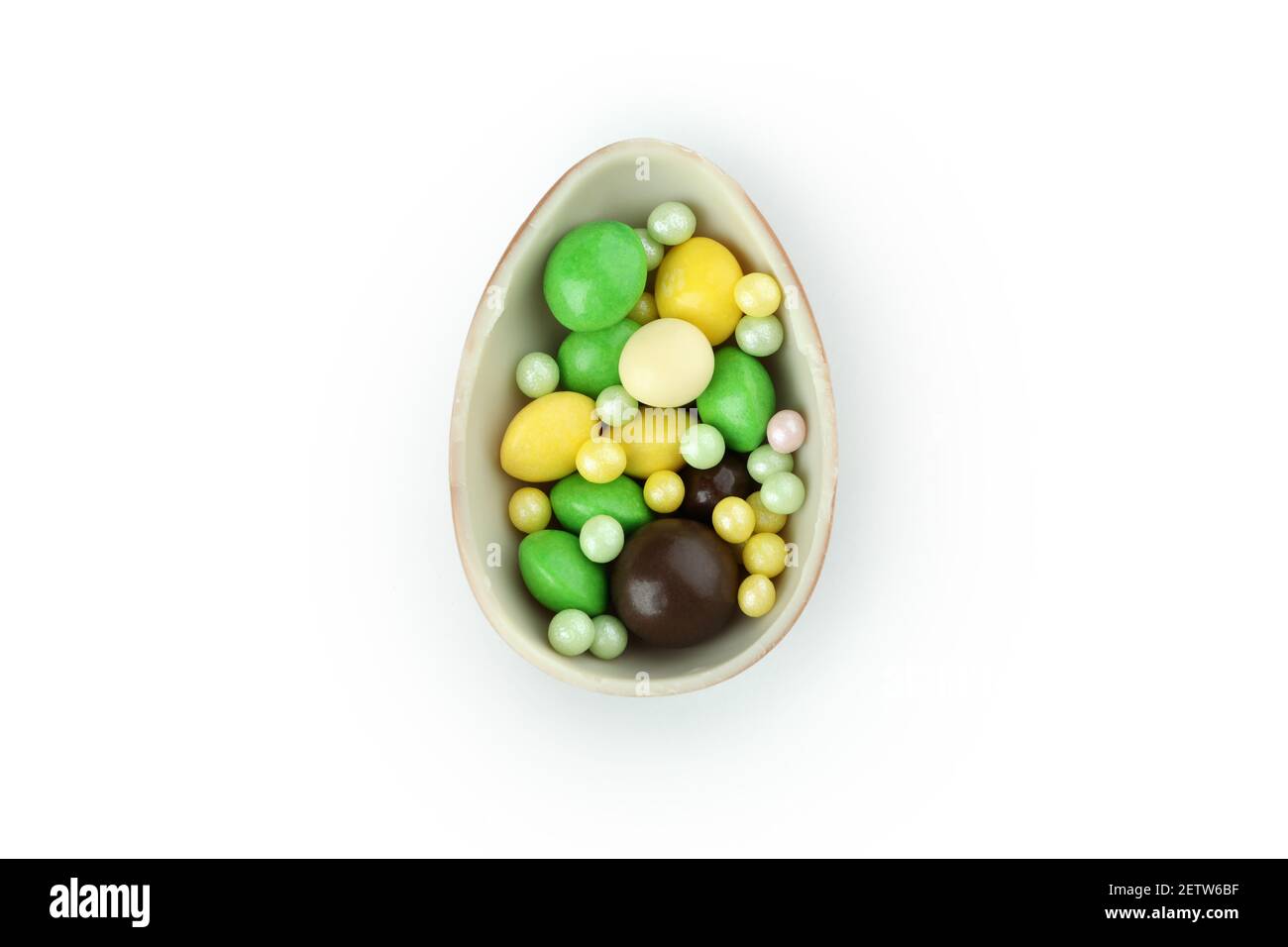 Mitad de huevo de chocolate con caramelos aislados sobre fondo blanco Foto de stock