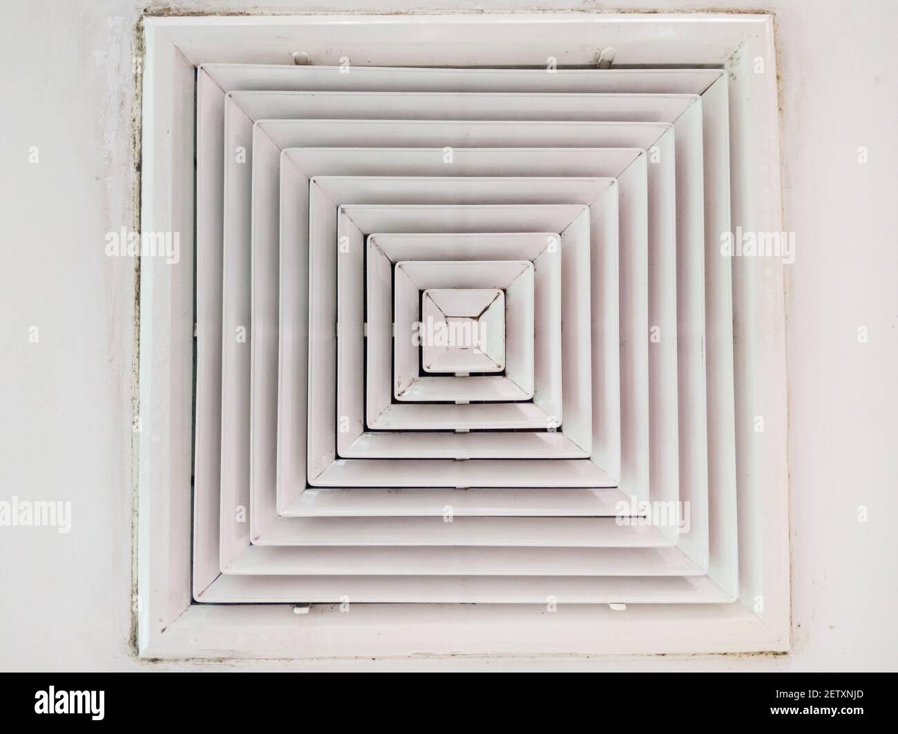 Cuadrado cubierta de rejilla de conducto de aire acondicionado blanca  contra el suelo con alfombra marrón Fotografía de stock - Alamy