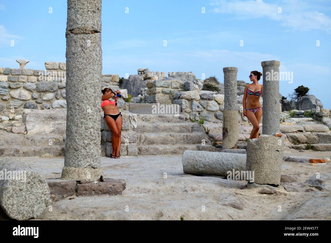 Niña en un bikini posando y haciéndose tomar su fotografía En las ruinas de la Basílica de Agios Stefanos en Kefalos on La isla griega de Kos Foto de stock