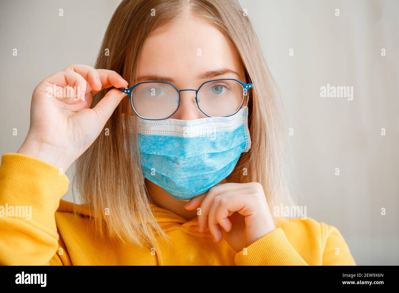 Gafas de niebla que se usan en la mujer joven. Niña adolescente en azul  protector médico máscara facial y gafas toallitas gafas borrosas niebla  maltratadas gafas. Nueva normalidad Fotografía de stock 