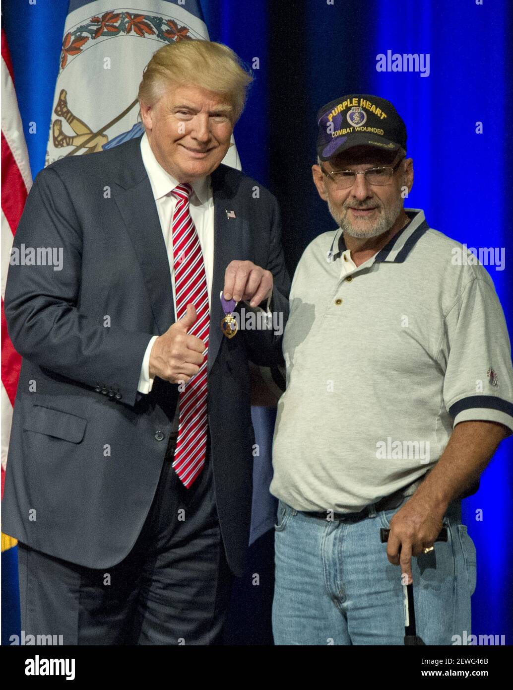 Donald J. Trump, el candidato republicano a presidente de los Estados  Unidos, muestra un corazón púrpura que le dio el teniente coronel Louis  Dorfman, derecho, en una presentación de campaña en Briar