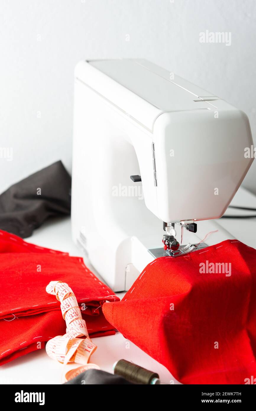 Máquina de coser moderna con tela roja y gris, cinta métrica y hilo, corte  y costura en casa, ocio en casa y hobby Fotografía de stock - Alamy