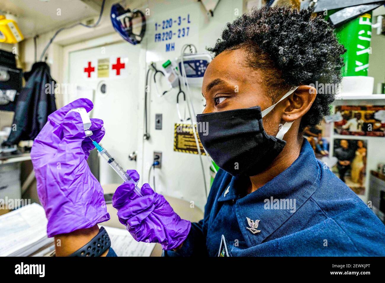 Hospital Corpsman 3rd clase Dejah Clark, de Houston, elabora una dosis de vacuna contra la gripe en el médico principal a bordo del misil guiado Arleigh Burke Foto de stock