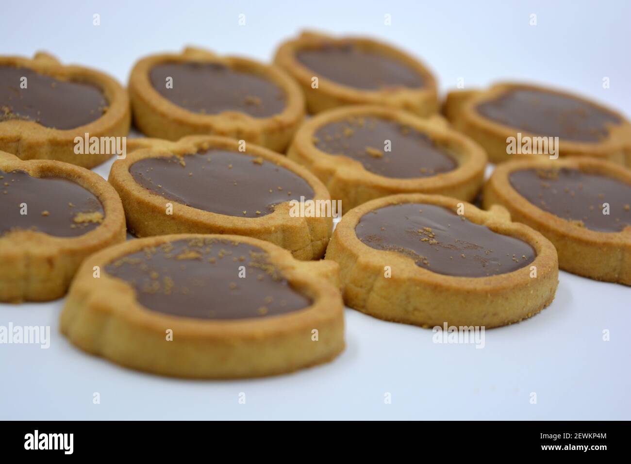 Deliciosas y dulces galletas en forma de manzana con relleno de nuez de chocolate marrón situado sobre un fondo blanco. Foto de stock