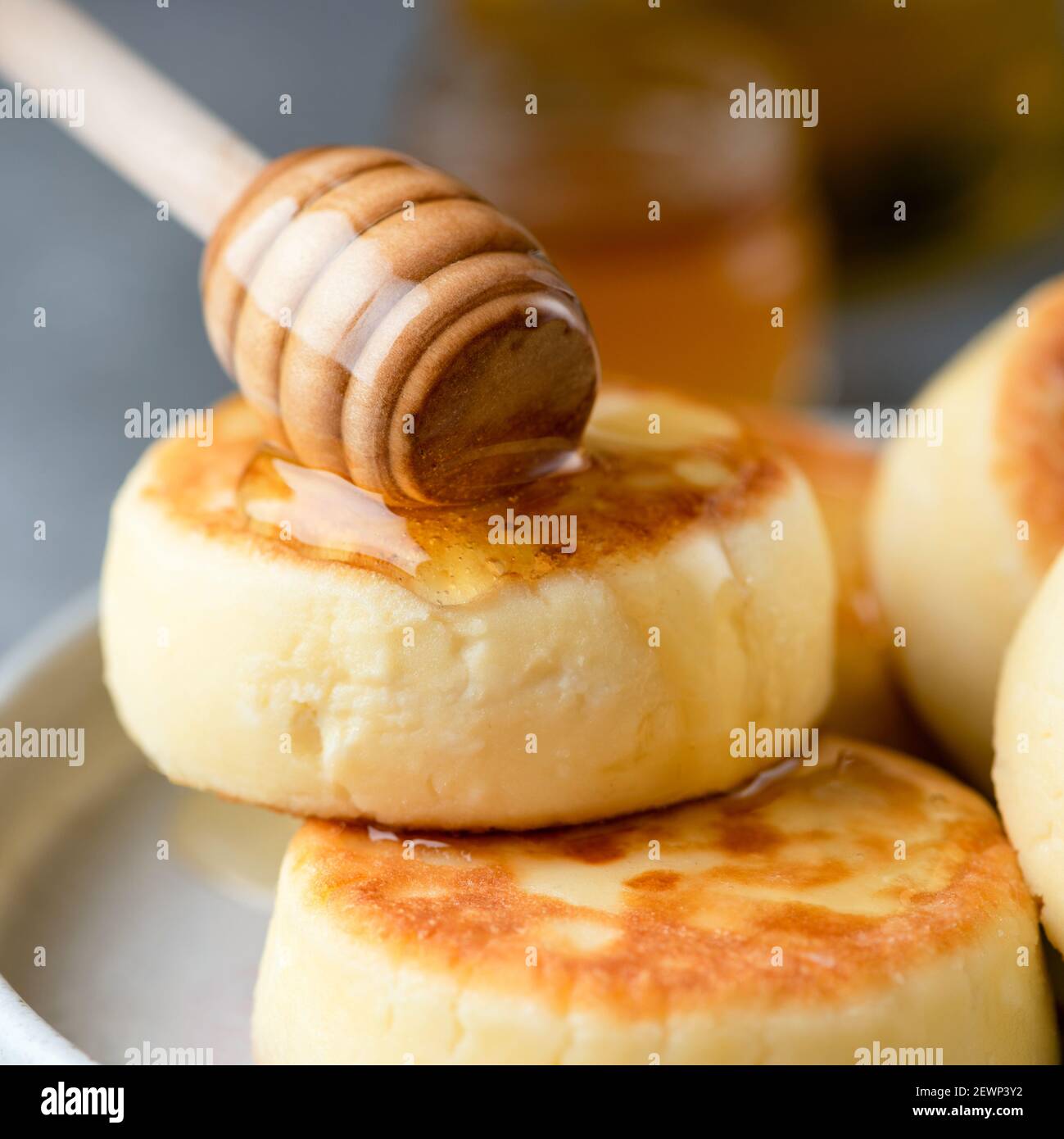 Frituras de queso cottage Sirniki, panqueques de queso dulce ruso servidos con miel. Vista de primer plano Foto de stock