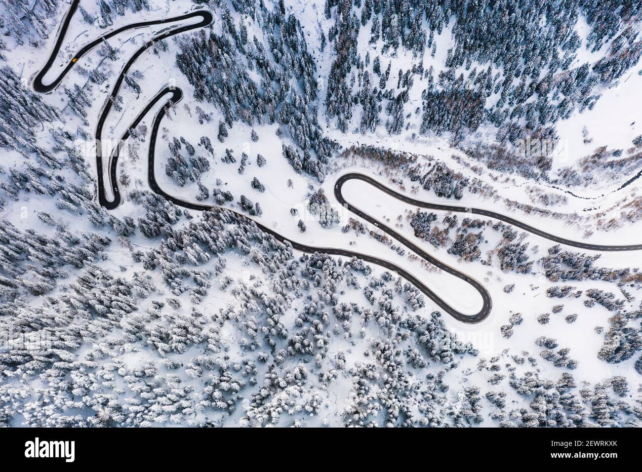 Vista aérea de la carretera de montaña de Maloja Pass que cruza el bosque de invierno cubierto de nieve, Cantón de Graubunden, Suiza, Europa Foto de stock