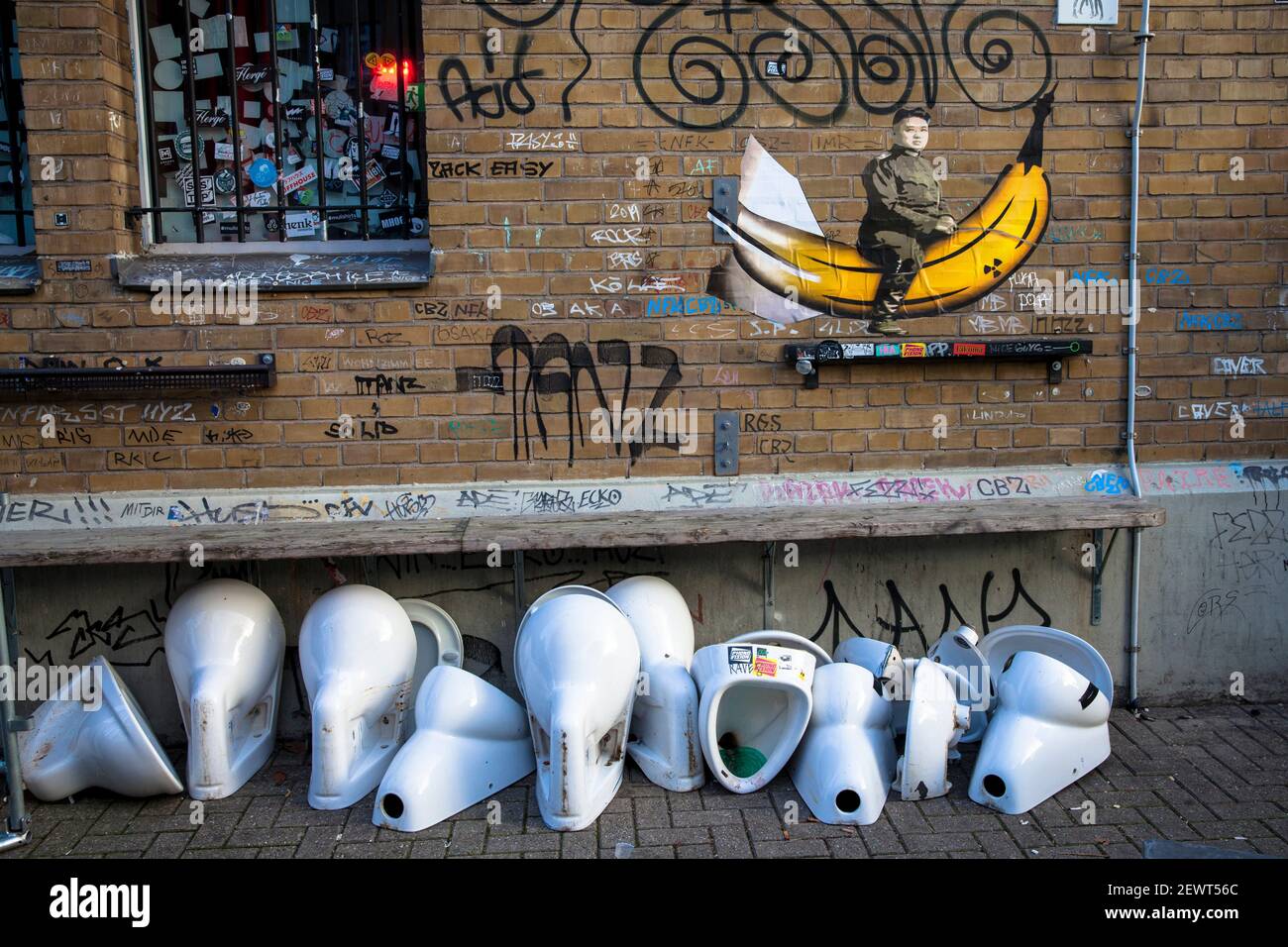 Graffiti del dictador norcoreano Kim Jong-un en su plátano nuclear y urinarios viejos y cuencos del inodoro en la estación oeste de Colonia, Colonia, Alemania. Graff Foto de stock