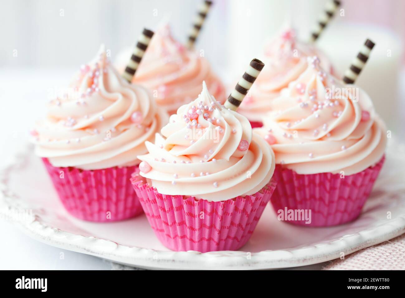 Cupcakes rosados decorados con pajitas de chocolate Foto de stock