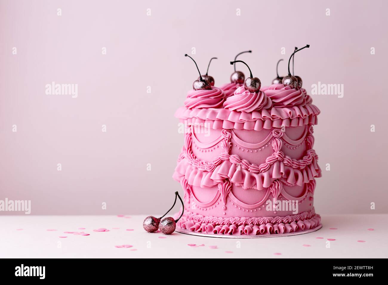 Pastel de cumpleaños ornamentado con volantes y cerezas de crema de mantequilla de estilo vintage Foto de stock
