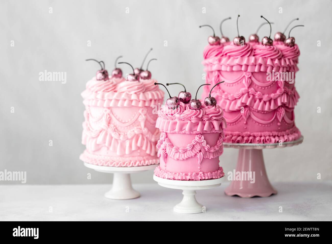 Tres pasteles de celebración de crema de mantequilla de estilo vintage rosa Foto de stock