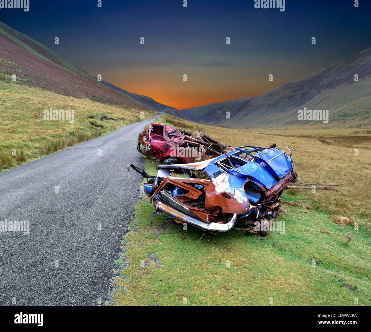 Coches naufragados en una carretera de montaña en Gales (con cielo apocalíptico alterado digitalmente). Foto de stock