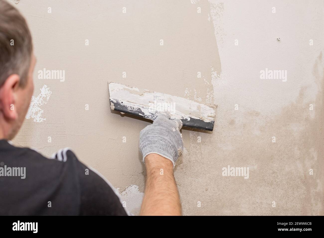Master está aplicando masilla blanca sobre una pared y manchas por cuchilla  para masilla en una sala de Rehabilitación de casa en el día Fotografía de  stock - Alamy