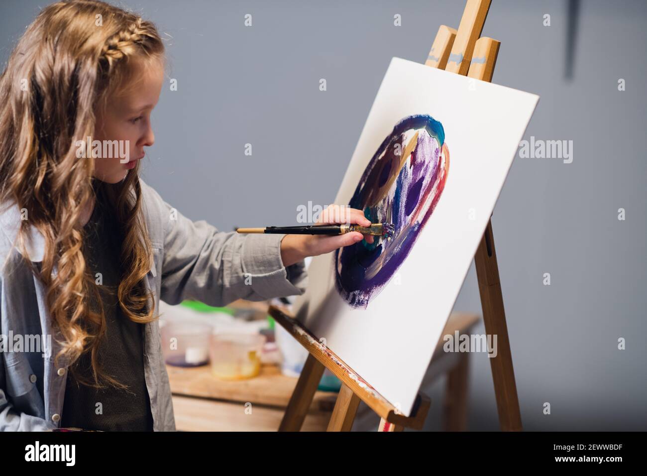Primera lección en la escuela de arte, una niña aprende a dibujar y hace su  primera pintura al óleo sobre lienzo Fotografía de stock - Alamy