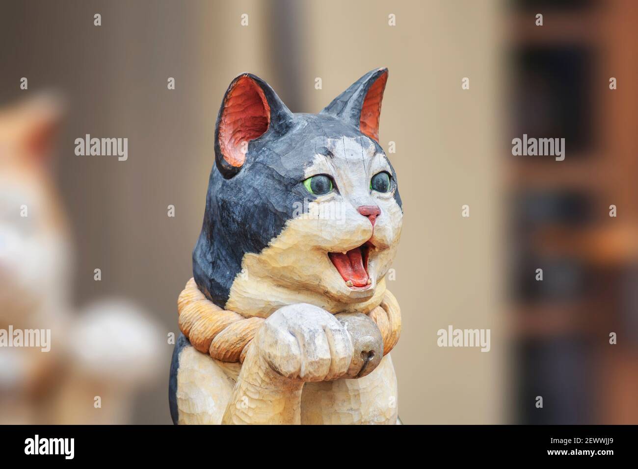 Monumental Melancolía Patentar tokio, japón - febrero 28 2021: Cerca de una escultura de madera que  representa un lindo gato japonés maneki-neko con la boca abierta y una pata  levantada en un ser Fotografía de