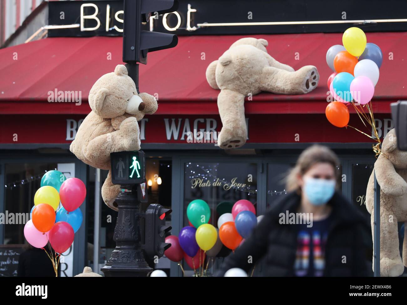 París, osos de peluche gigantes se ven en un restaurante que ofrece  servicios para llevar en París. Restaurantes. 30th de Oct de 2020. Una  mujer pasa por osos de peluche gigantes fuera
