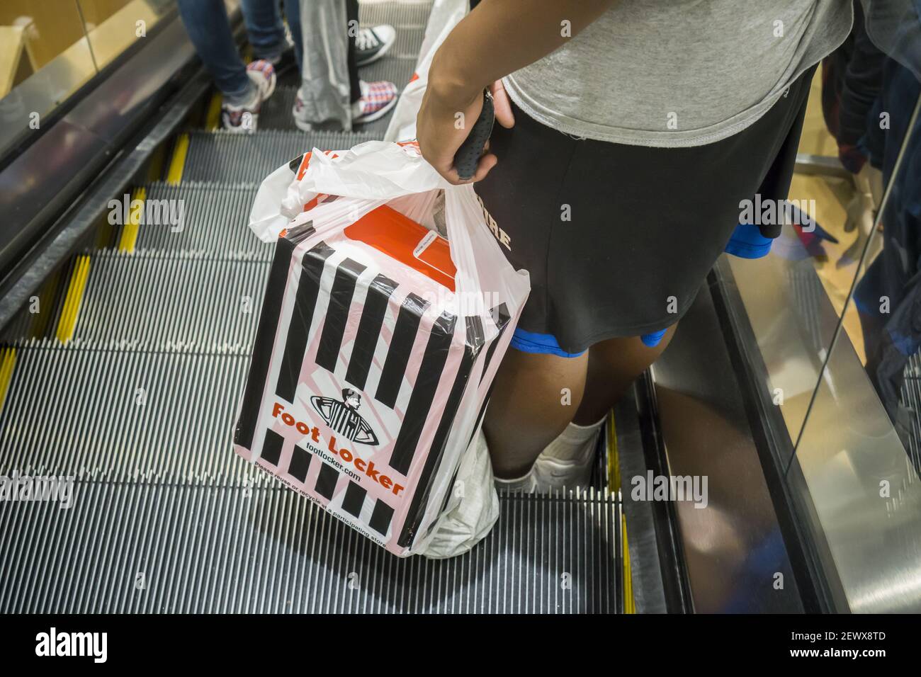 Un comprador con su compra Foot Locker en una escalera mecánica en una  tienda en Brooklyn en Nueva York el sábado, 8 de agosto de 2015. Foot Locker  Inc. Reportó ganancias y