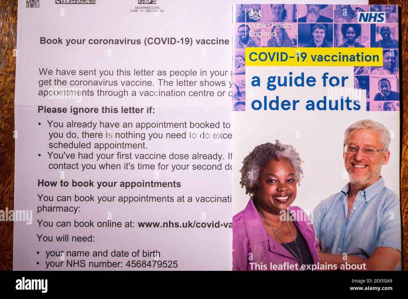 Carta de invitación del NHS para reservar una vacuna contra el coronavirus para una persona mayor de 60 años de edad con folleto de orientación. Retocado para eliminar información personal. Foto de stock