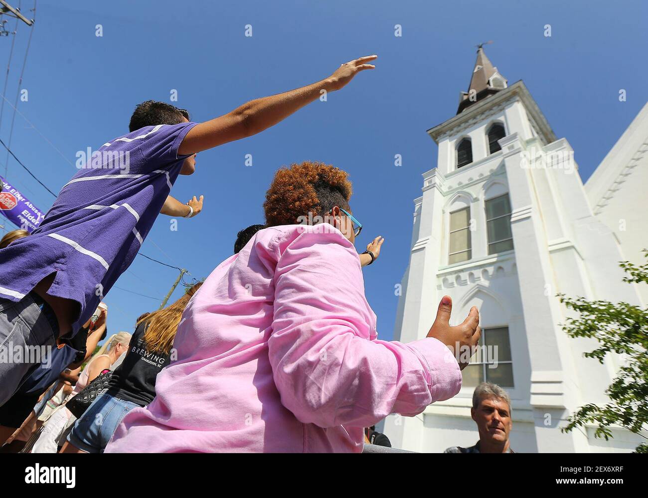 La gente levanta los brazos en el aire mientras escucha el servicio de  adoración dominical emocional transmitido en vivo en los oradores fuera del  'Madre' Emanuel . Iglesia el domingo, 21 de