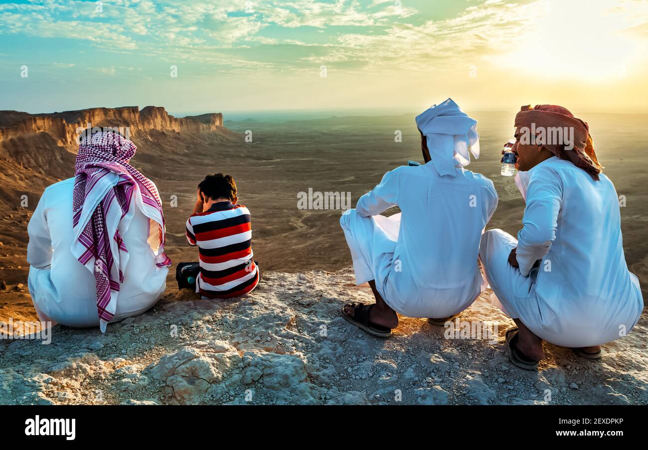 Un hombre árabe y su hijo sentados en Edge of the World, un punto de referencia natural y popular destino turístico cerca de Riyadh -Arabia Saudita.08-Nov-2019. Seleccione Foto de stock