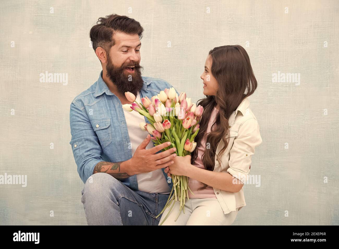 celebración del día de las mujeres. niño y papá preparan flores para el día de las madres. primavera y belleza. padre e hija con flores. Feliz retrato familiar. Chica saludando a papá celebración del día de las mujeres. niño y papá preparan flores para el día de las madres. primavera y belleza. padre e hija con flores. Feliz retrato familiar. Chica saludando a papá