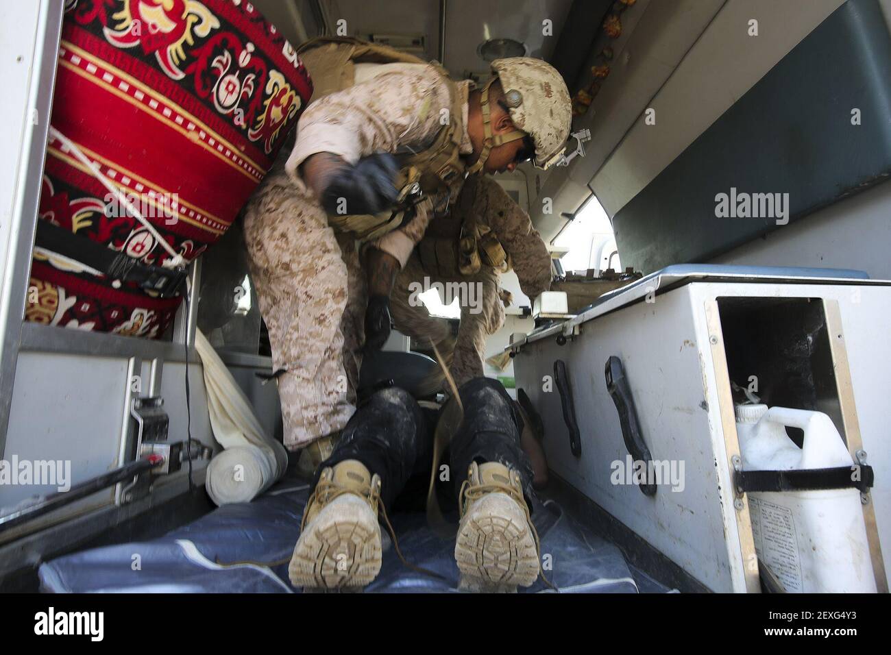 El Seaman de la Marina de los Estados Unidos Apprentice Mikail Garib, un hospitalman con la Compañía B, Batallón 1st, Regimiento Marino 7th, Fuerza de tarea Aérea Marina de propósito Especial – respuesta a crisis – comando Central, trata a un soldado iraquí por lesiones relacionadas con el combate en al Taqaddum, Irak, 28 de noviembre de 2015. Ocasionalmente, soldados iraquíes heridos son transportados desde campos de batalla en Ramadi y Fallujah, Irak, a al Taqaddum para recibir tratamiento médico del personal estadounidense. Los cadáveres de la Marina de los Estados Unidos con â€œBravoâ€ Company, 1st mil millones, 7th infantes de marina, son los primeros en atender a las víctimas. Marines y marineros de EE.UU. Con S Foto de stock