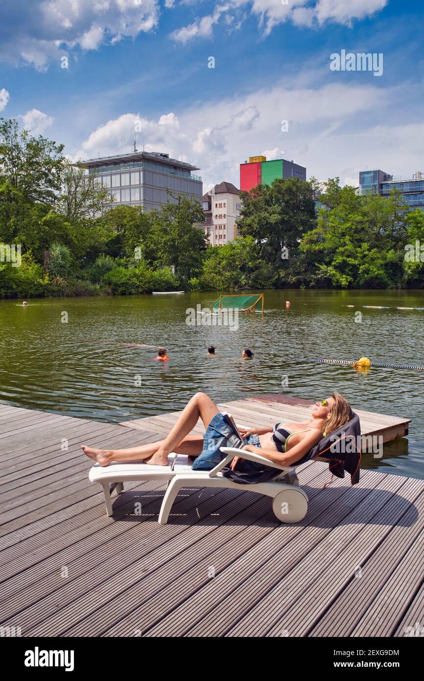 Mujer joven relajándose en el muelle del lago. Vacaciones en la ciudad.Frankfurt am Main, Hessen, Alemania Foto de stock