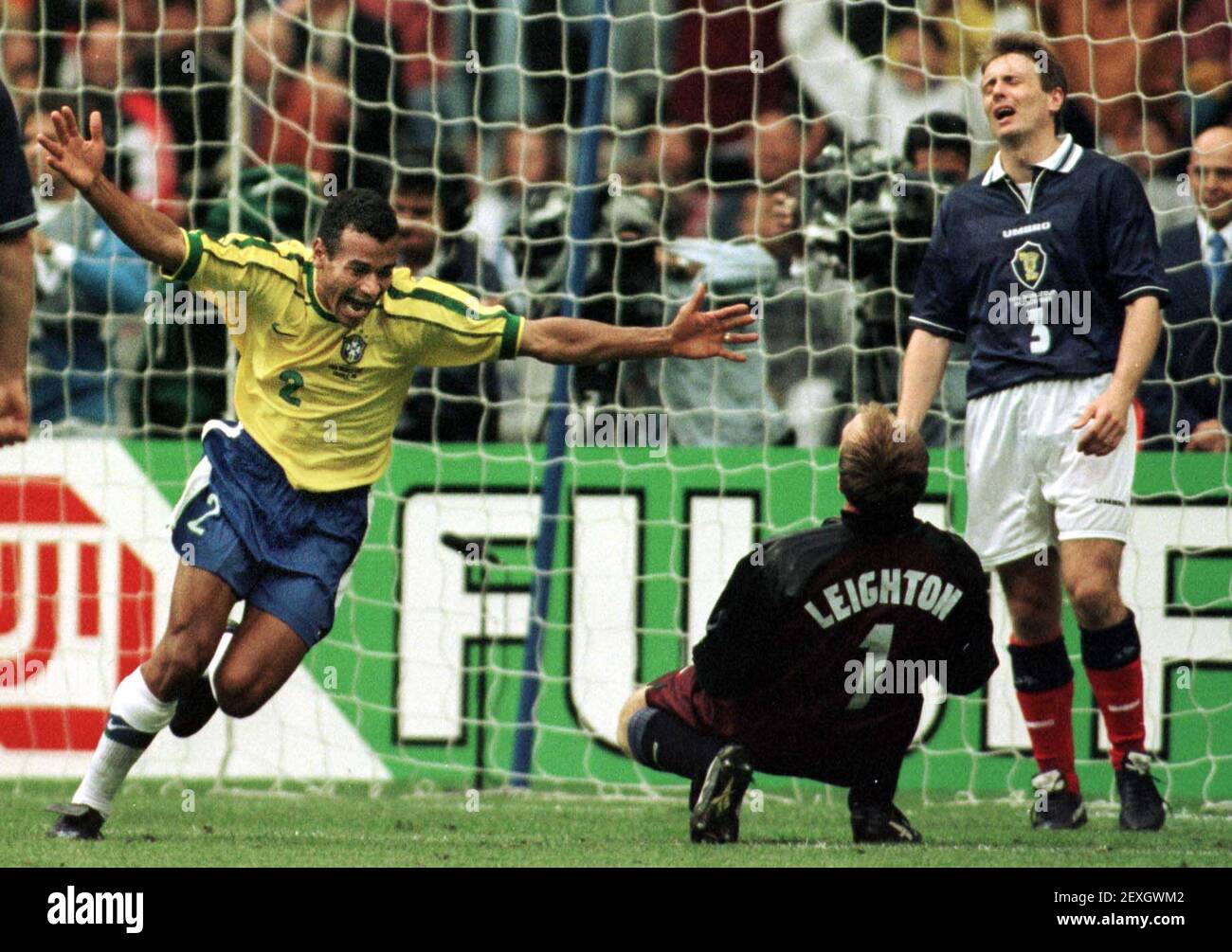 Cafu Brasil celebra después de anotar contra el 1998 de junio Escocia durante El partido de apertura de la Copa del Mundo en París en El Stade de France como Tommy Boyd, defensor de Escocia, mira encendido Foto de stock