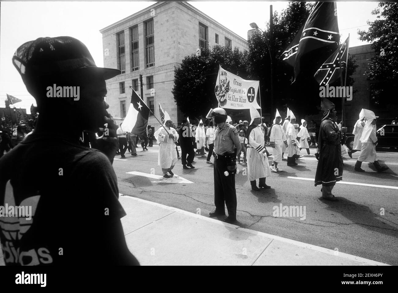 Gainesville, GA, EE.UU. 10th de enero de 2019. Un residente local observa como miembro del Waco, Texas Caballeros del Ku Klux Klan marcha por el centro de la ciudad en una protesta contra los derechos civiles. C. 1987 (imagen de crédito: © Robin RayneZUMA Wire) Foto de stock