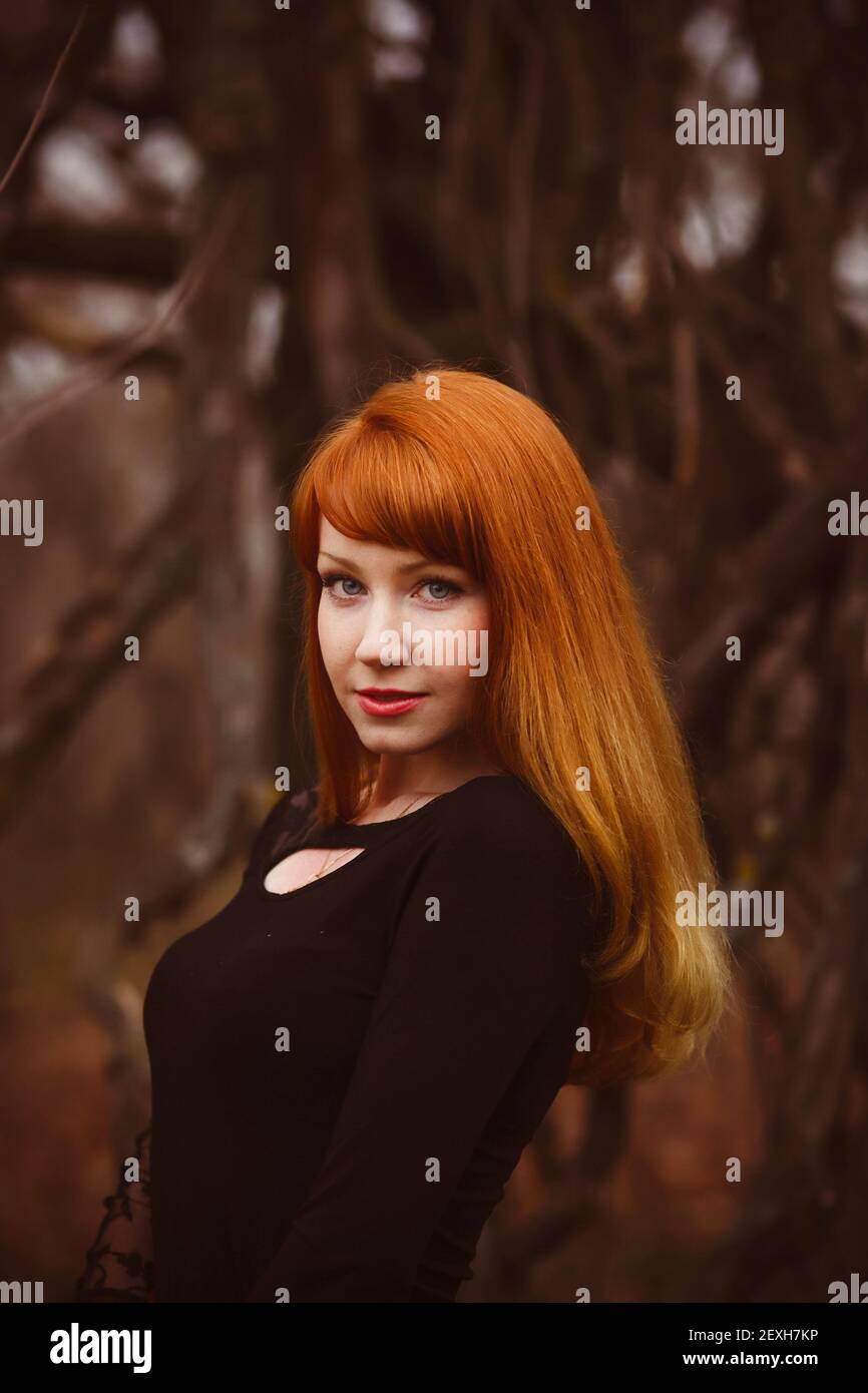 Cara de pelo rojo modelo chica en negro mujer vestido seco otoño oscuro  Fotografía de stock - Alamy