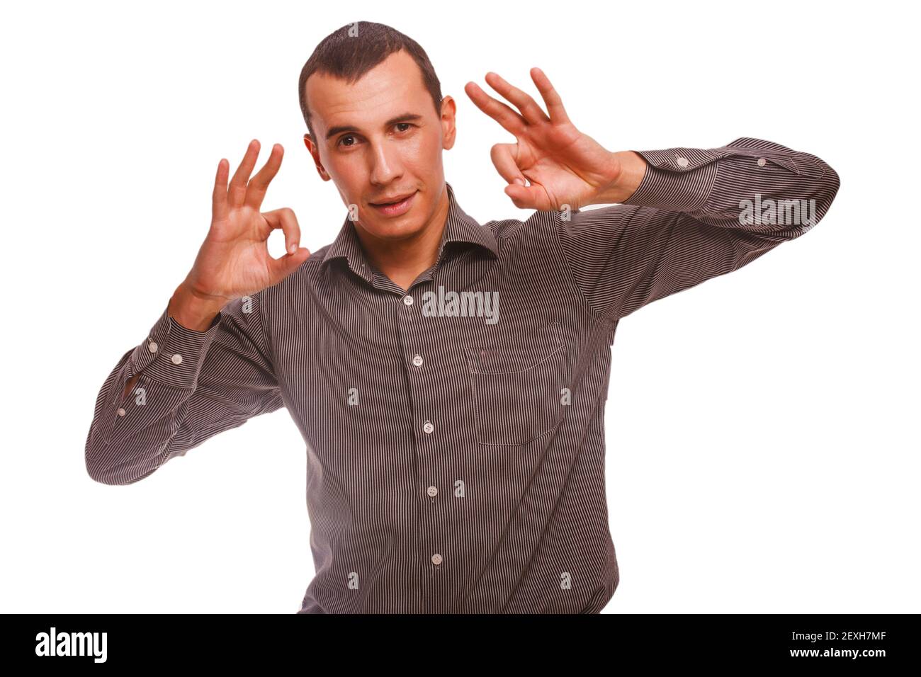 Brunet hombre en una camisa a rayas mostrando signo de buen gesto ok isola Foto de stock
