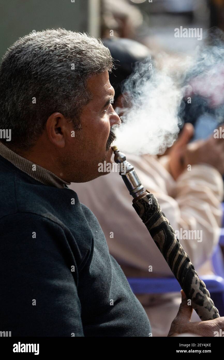 Perfil retrato de un hombre egipcio local que exhala humo de una pipa de shisha en el barrio islámico de el Cairo, Egipto Foto de stock
