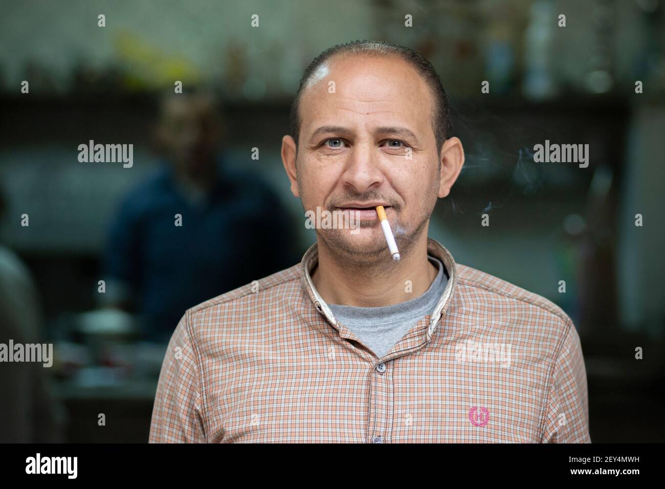 Retrato de un camarero egipcio que fumaba un cigarrillo en un café (ahwa) en el centro de el Cairo, Egipto Foto de stock