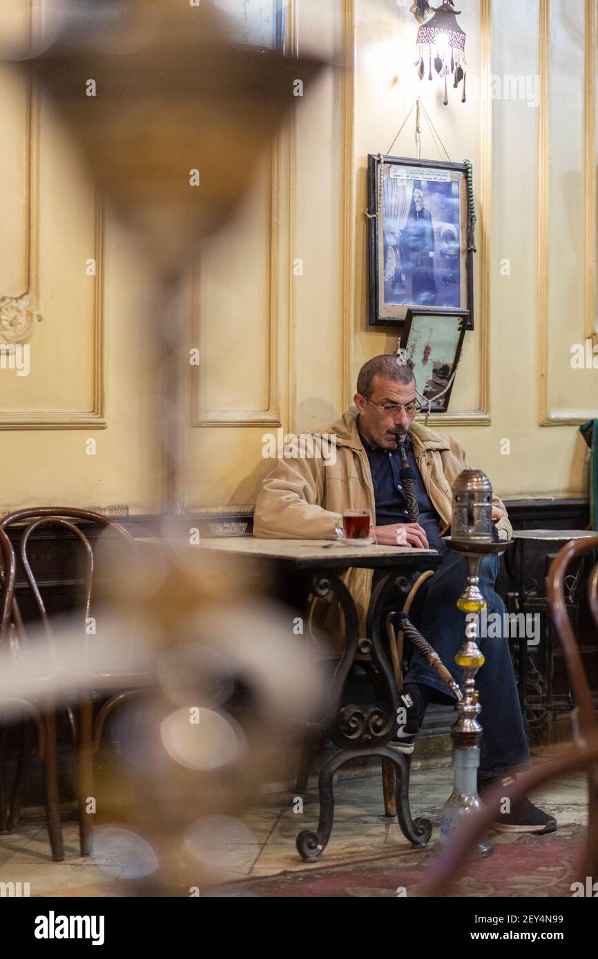 Retrato franco de un hombre egipcio fumando una pipa de shisha dentro de un café tradicional (ahwa) en el Cairo, Egipto Foto de stock