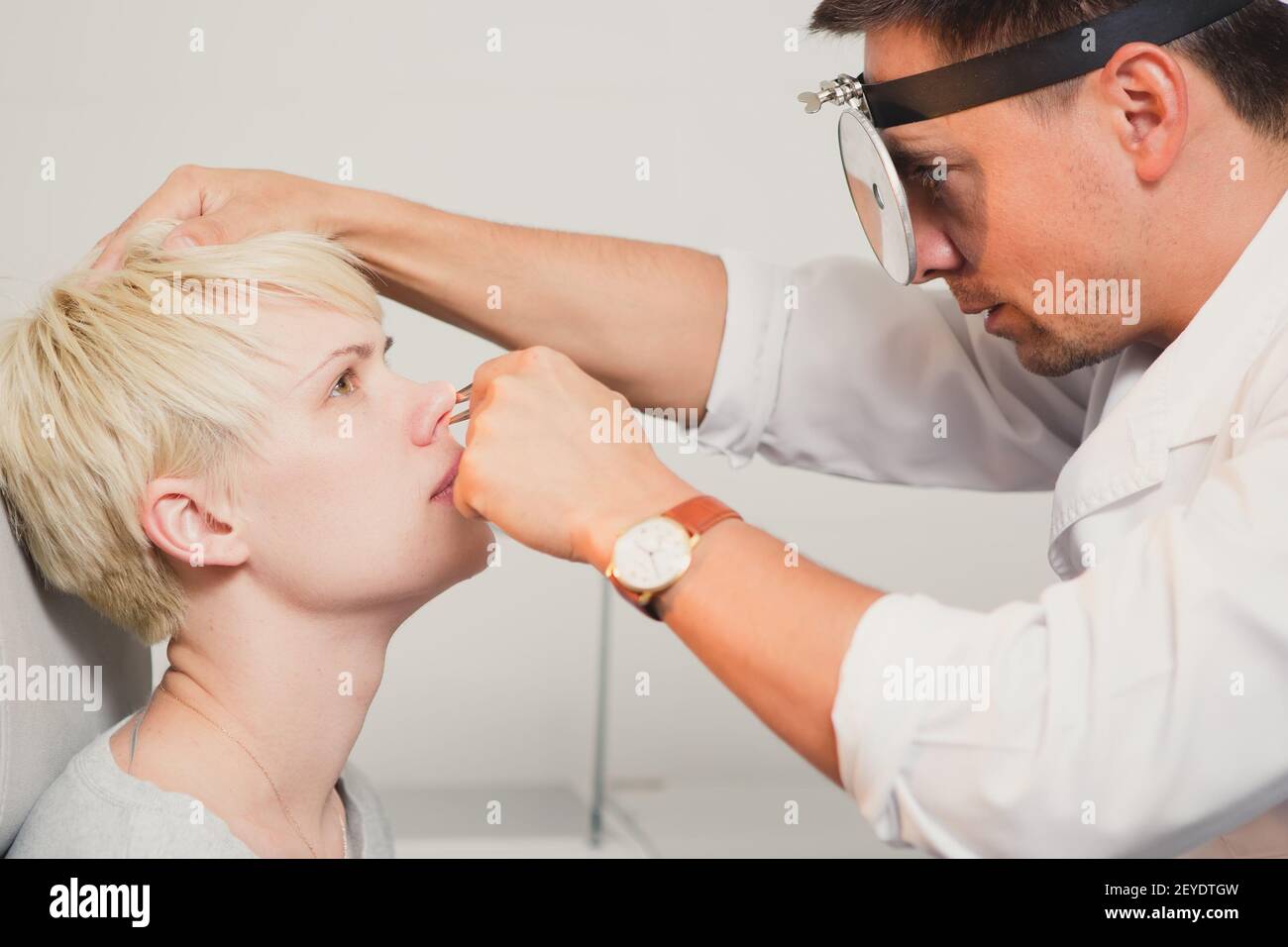 Doctor ENT comprobación de oreja con otoscopio para paciente Foto de stock