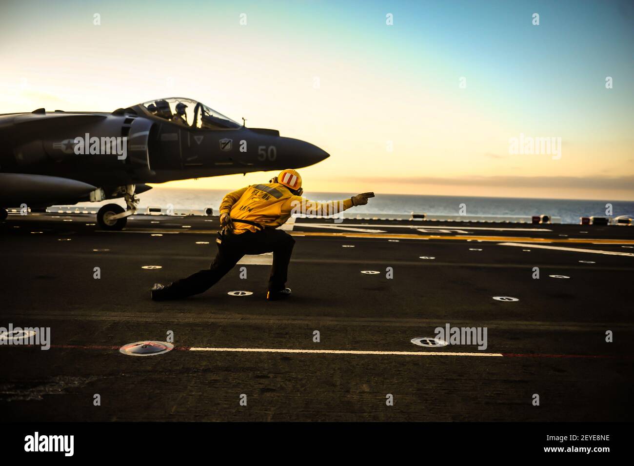 Aviación de la Marina de los EE.UU. El avión Mate de Boatswain Ronald García señala al piloto de un avión AV-8B Harrier II asignado al elemento de combate aéreo de la Unidad Expedicionaria Marina 13th antes del despegue en la cubierta de vuelo del buque de asalto anfibio USS Boxer (LHD 4) En el Océano Pacífico 13 de junio de 2013. El Boxer estaba realizando entrenamiento previo al despliegue durante el ejercicio anfibio Dawn Blitz. Dawn Blitz es un ejercicio impulsado por escenarios dirigido por la flota 3rd de EE.UU. Y la Fuerza Expedicionaria Marina 1st para probar a los participantes en la planificación y ejecución de operaciones anfibias a través de una serie de tr en vivo Foto de stock