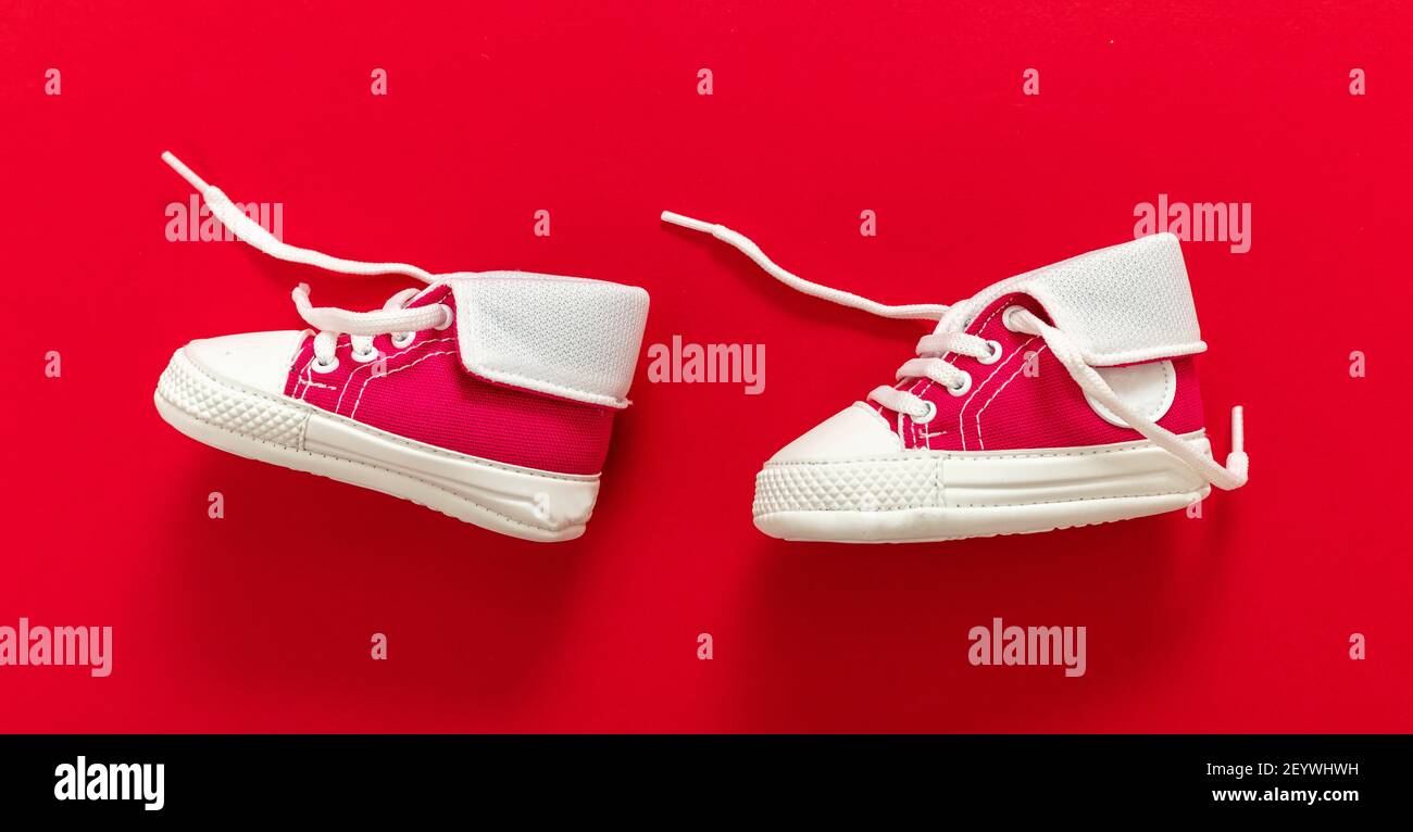 Zapatos deportivos para bebés caminando sobre fondo de color Zapatillas de lona tamaño pequeño para niños. Primeros pasos para los Fotografía de stock - Alamy