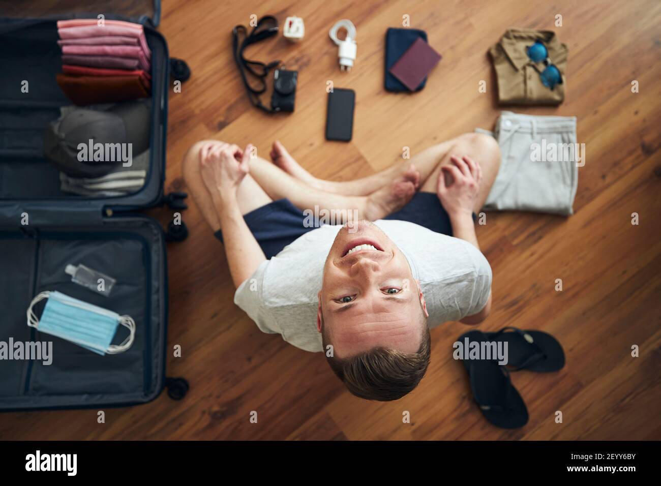 Feliz viajero se está preparando para viajar en nueva normalidad. Hombre  maleta con pasaporte, teléfono inteligente, ropa y máscaras y desinfectante  de manos para Fotografía de stock - Alamy