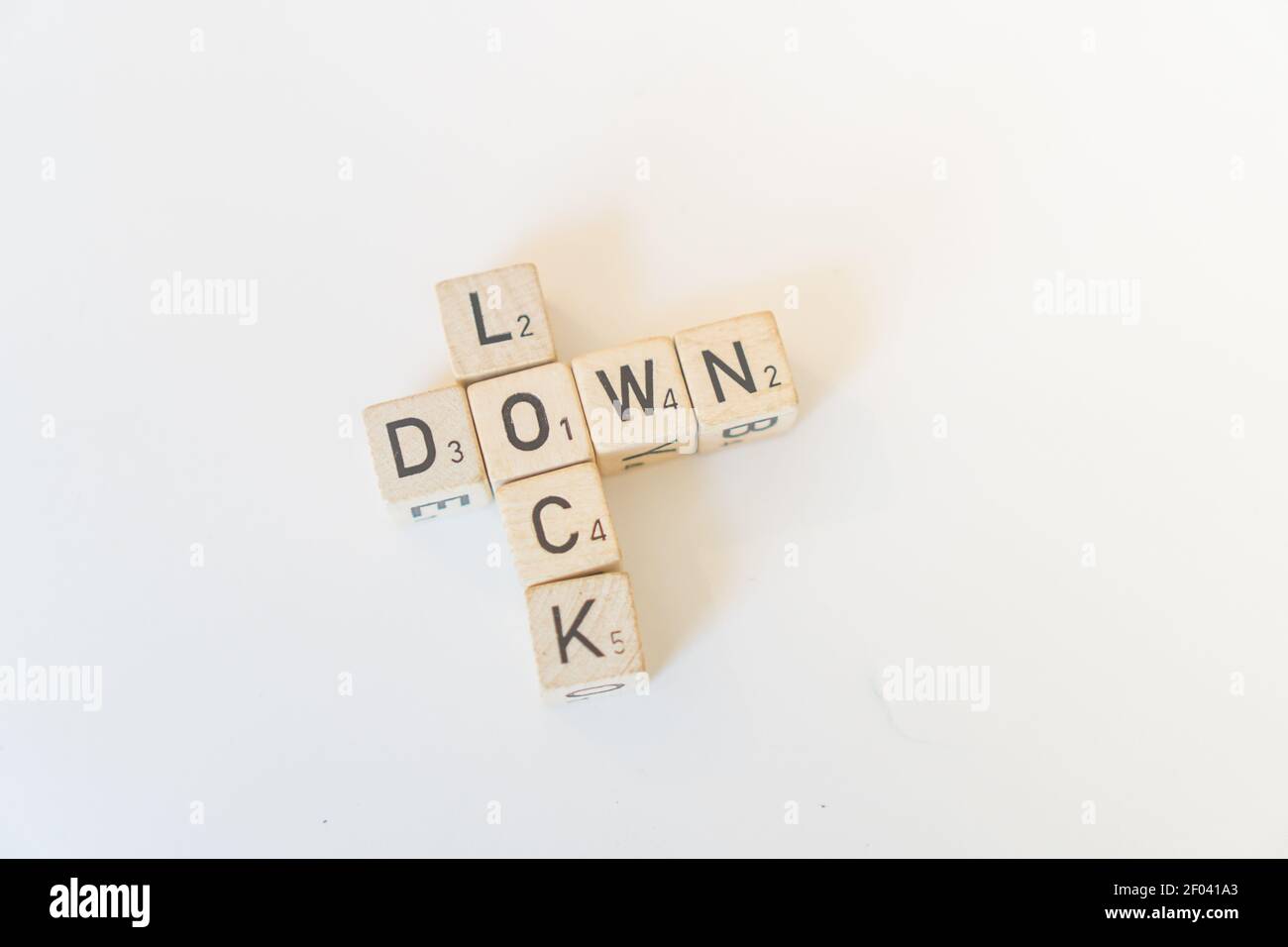 Las baldosas de madera o cubos de juego con letras deletrean Lock Down, el resultado de la pandemia Foto de stock
