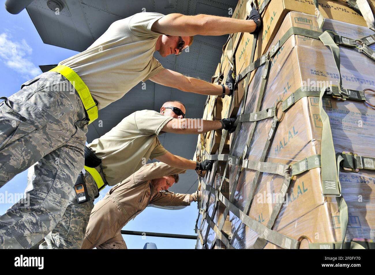 1 de agosto de 2010 - Bagram Airfield, Afganistán - los aviadores de la Fuerza Aérea de EE.UU. Empujan paletas de comidas halales a un C-130H en Bagram Airfield, Afganistán, 1 de agosto de 2010. Las comidas de ayuda humanitaria se entregarán al Pakistán como parte de una misión de socorro humanitario. Las inundaciones monzónicas provocadas por lluvias torrenciales han devastado cientos de miles en Pakistán. La tripulación, asignada al Ala Expedicionaria Aérea 455th, forma parte de una Unidad de la Guardia Nacional Aérea desplegada desde Peoria, Illinois. Photo Credit: Christopher Boitz/DOD/Sipa Press (LANZADO)/1008022214 Foto de stock