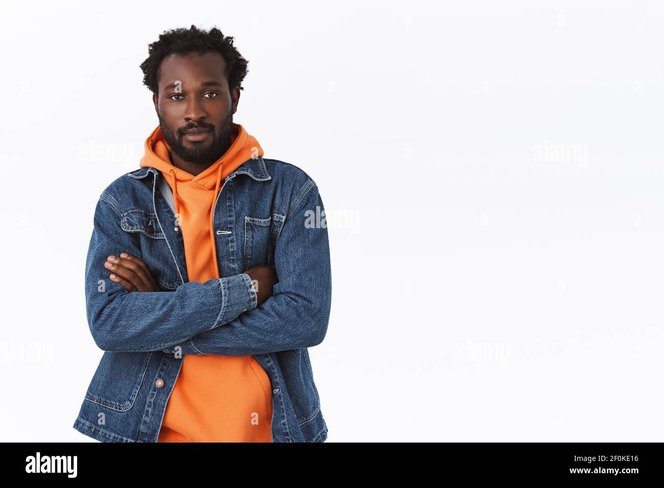 Tiro con cintura para arriba segura y con estilo afroamericano vestido para  la fiesta de Halloween, chaqueta vaquera, sudadera con capucha naranja,  cruzar las manos sobre el pecho en fresco Fotografía de