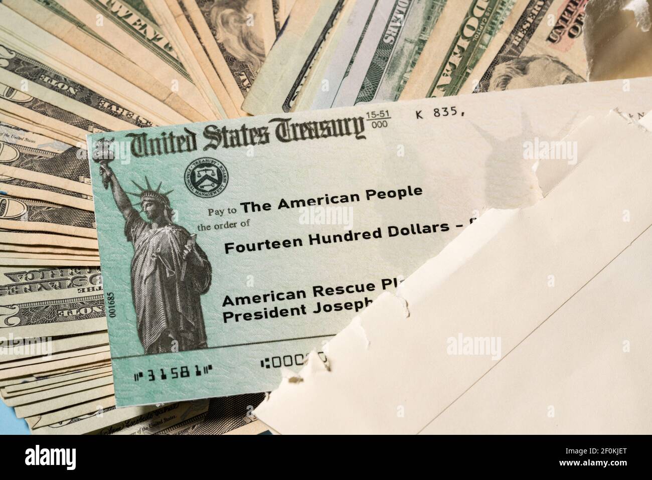 Pila de letras de 20 dólares con cheque ilustrativo del Tesoro de EE.UU