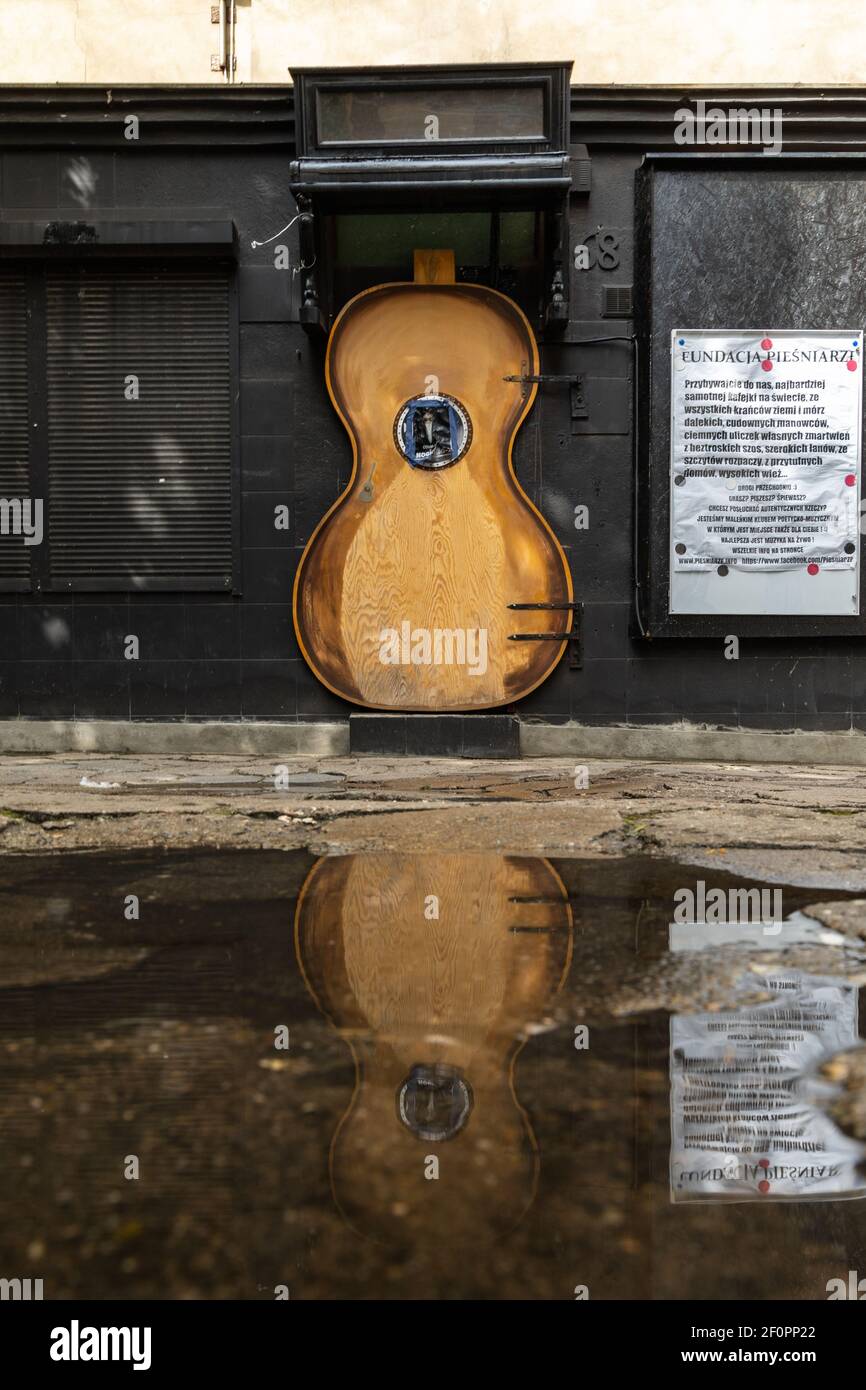 Wroclaw, Polonia - Mayo 03 2020: Puertas en forma de guitarra con piano  viejo sobre él reflejado en charco Fotografía de stock - Alamy