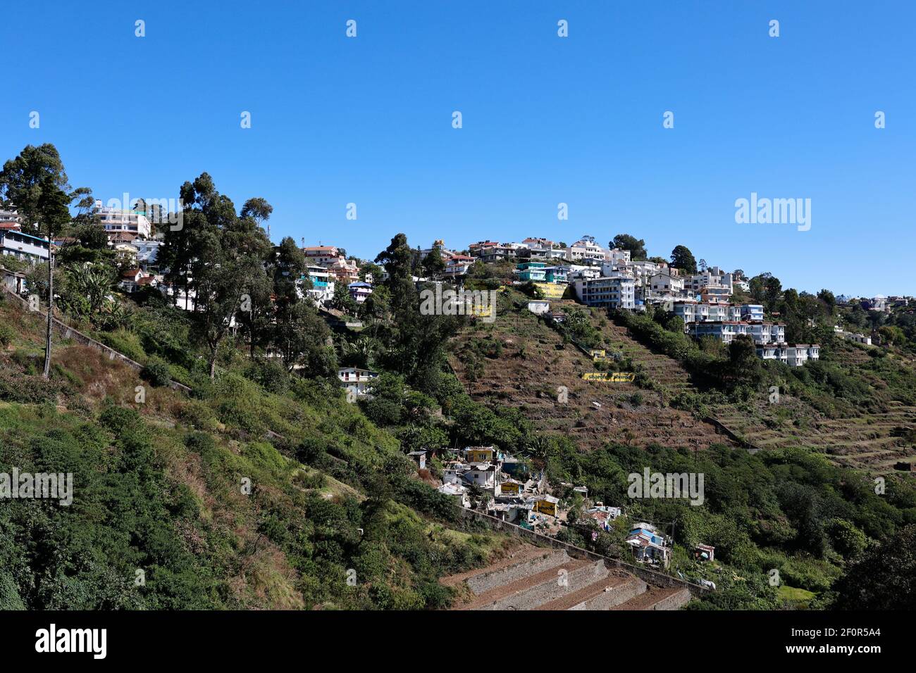 Vista de las casas construidas en las laderas de la montaña en la estación de la colina de Kodaikanal en Dindigul, Tamil Nadu, India Foto de stock