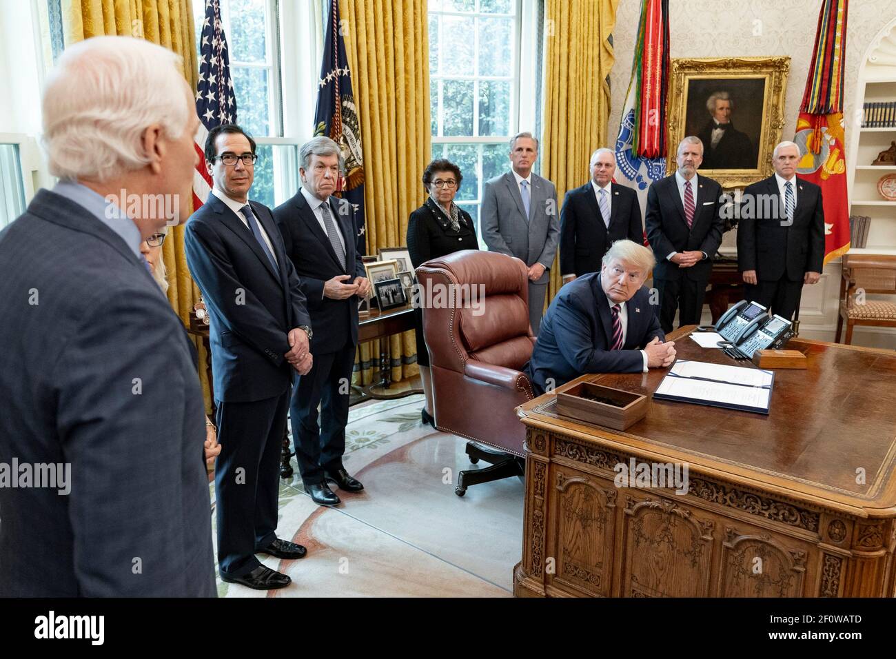 El presidente Donald Trump escucha al Senador John Cornyn R-Texas en sus palabras en la firma de la H.R. 266 – el Programa de Protección de cheque de pago y la Ley de mejora de la atención médica Viernes 24 2020 de abril en la Oficina Oval de la Casa Blanca. Foto de stock
