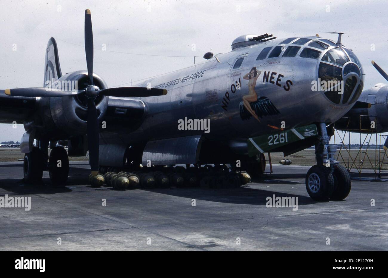Vista frontal derecha de tres cuartos del Boeing B-29 Superfortress con bombas debajo del avión. El arte de la nariz incluye un apodo con dibujo, 'Nip on Nees'. Foto de stock
