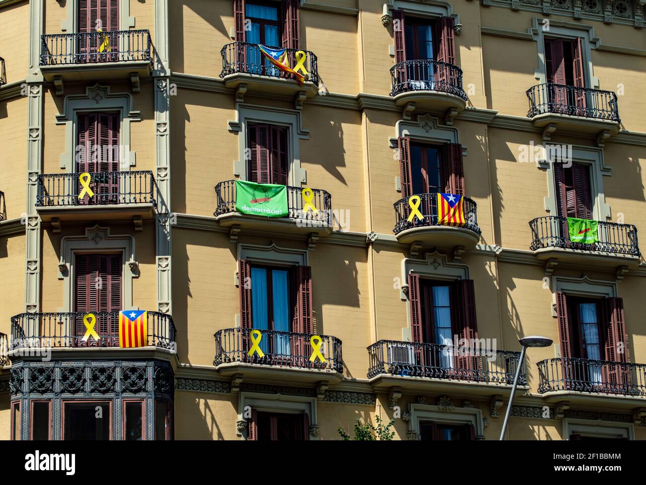 Barcelona, España - 24 de julio de 2019: Banderas catalanas y cintas de protesta en los balcones de un edificio de la ciudad de Barcelona, Cataluña, España Foto de stock