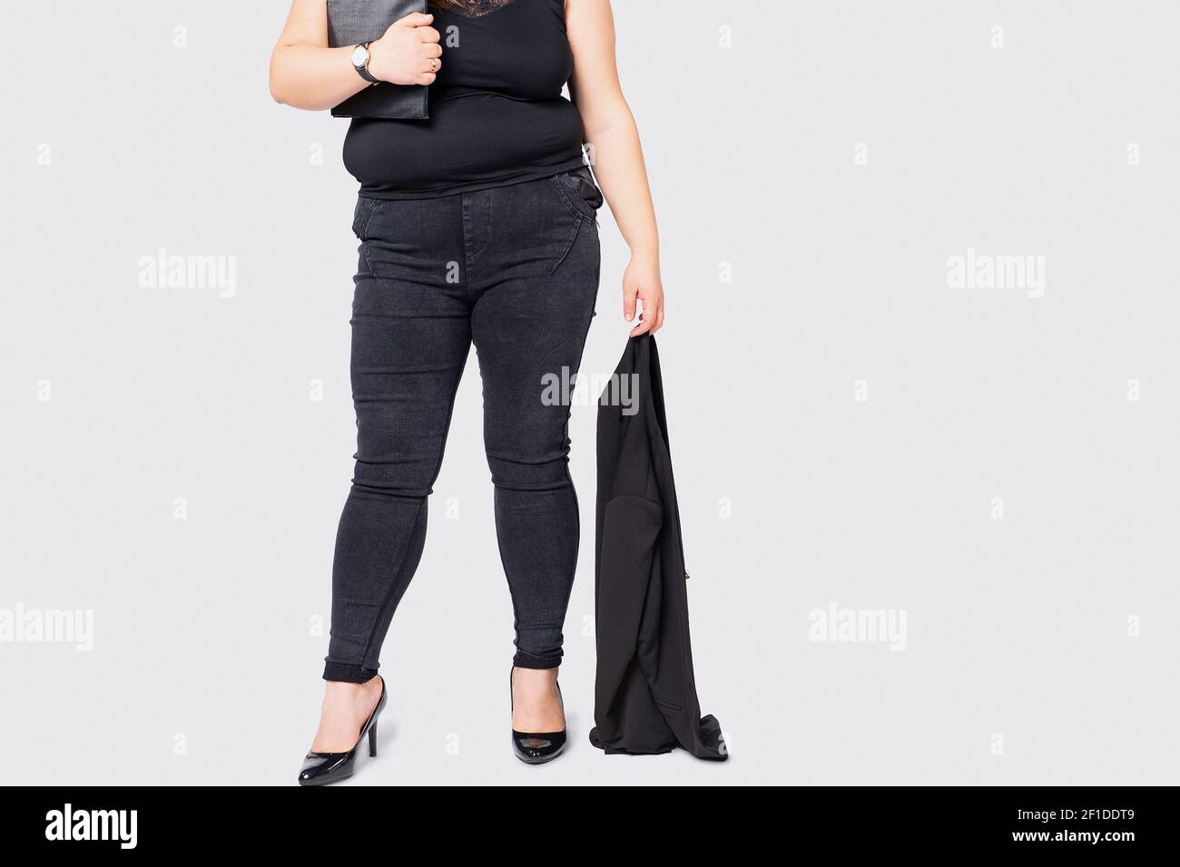 Foto recortada de piernas femeninas con sobrepeso. Más talla modelo chica  con traje formal y zapatos negros de pie aislado fondo gris. Mujer modelo  XXL Fotografía de stock - Alamy
