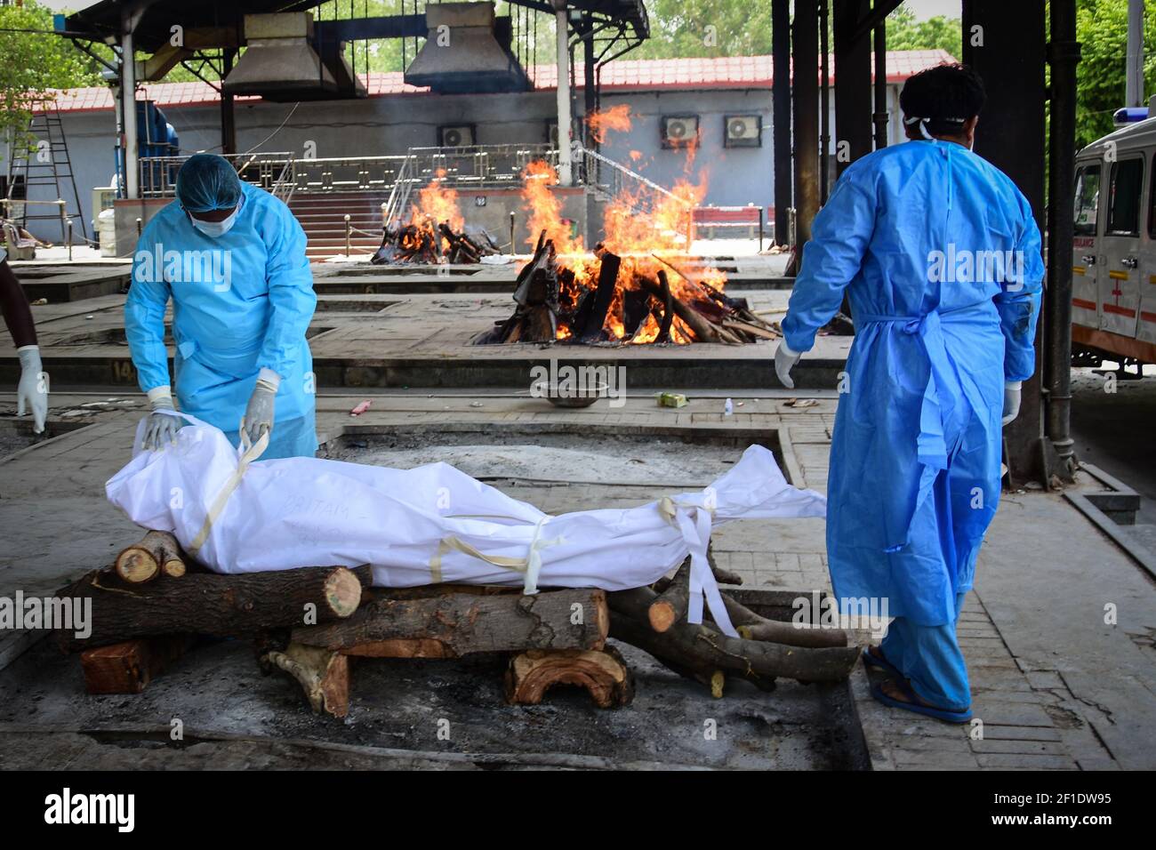 (NOTA DE LOS EDITORES: La imagen muestra la muerte) los trabajadores de salud preparan la pira para la cremación de una persona que murió debido a la enfermedad del coronavirus (COVID-19) en un crematorio en Nueva Delhi. Nueva Delhi (capital de la India) ha notificado oficialmente cerca de 77.240 casos confirmados y la muerte total de 2.492 el 27 de junio de 2020 por el coronavirus. Nigambodh Ghat, el crematorio más grande de Delhi, el Nigambodh Ghat ha estado trabajando horas extras desde que la capital de la India se convirtió en un punto de encuentro pandémico. Pero solo tres de los seis hornos se utilizan para los muertos del virus están funcionando tan lentamente, por eso la pira tradicional de madera debe ser Foto de stock