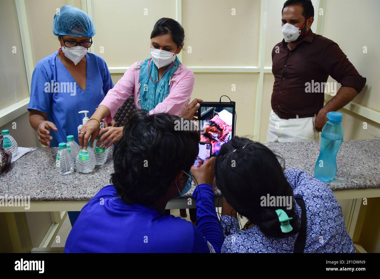 Los miembros de la familia hablan con su familiar, admitido para el tratamiento (COVID-19) utilizando las instalaciones de videoconferencia proporcionadas por el hospital del LNJP en Delhi. (Foto de Manish Rajput / SOPA Images/Sipa USA) Foto de stock